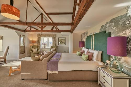 a bedroom with a large bed and a couch at Wivenhoe House Hotel in Colchester