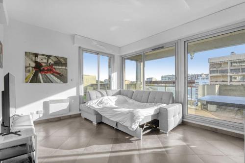 un salon avec un canapé et une grande fenêtre dans l'établissement Toit des Rêves - Parking - Stadium, à Toulouse