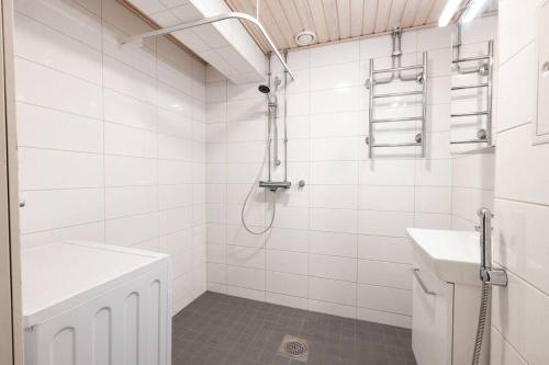 a white bathroom with a shower and a sink at 2ndhomes Cozy 1BR Apartment w/ Balcony next to tram stop in Helsinki