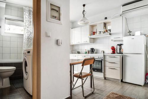 a white kitchen with a table and a chair at Sotiria House in Preveza