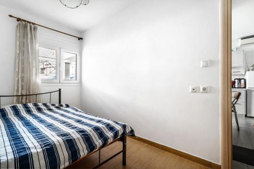 a bedroom with a bed with a blue and white comforter at Sotiria House in Preveza