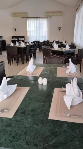 a dining room with tables and chairs with white napkins at Regina Resort El Sokhna in Ain Sokhna
