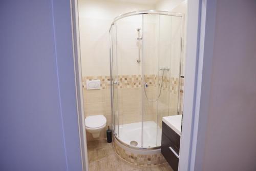 y baño con ducha, aseo y lavamanos. en Elegant & Stylish Center Apartments!, en Praga