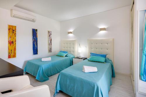 2 Betten in einem Zimmer mit blauer Bettwäsche in der Unterkunft Charming Vale do Lobo Villa - 4 Bedrooms - Villa Quadradinhos 22 - Private Pool and Close to Amenities - Algarve in Almancil