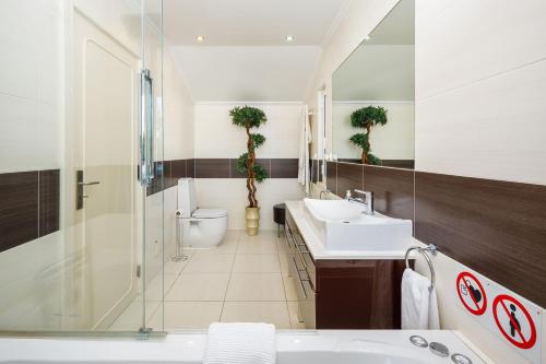 ein Badezimmer mit zwei Waschbecken, einer Dusche und einem WC in der Unterkunft Charming Vale do Lobo Villa - 4 Bedrooms - Villa Quadradinhos 22 - Private Pool and Close to Amenities - Algarve in Almancil