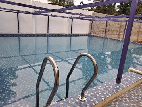 una piscina con una escalera de metal que conduce al agua en SS HOME STAY, en Bangalore