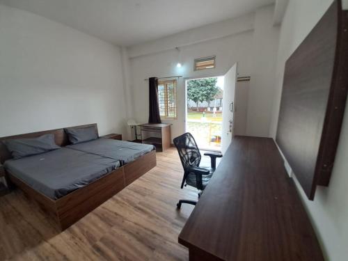 a bedroom with a bed and a desk and a chair at SS HOME STAY in Bangalore