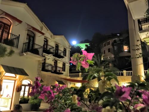 um grupo de edifícios à noite com flores cor-de-rosa em Patara Prince Hotel & Resort - Special Category em Kalkan