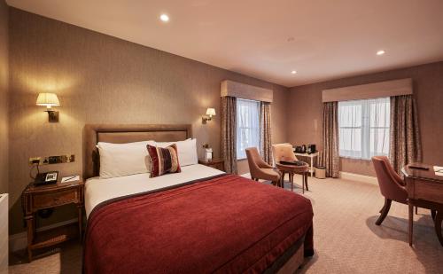 a hotel room with a bed and a desk at Wivenhoe House Hotel in Colchester