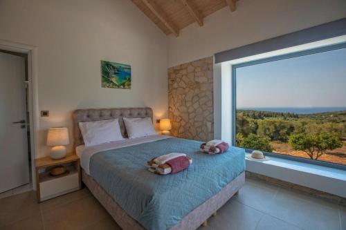 a bedroom with a bed and a large window at Majestic Stone Villa Sea View Pool in Andipáta Erísou