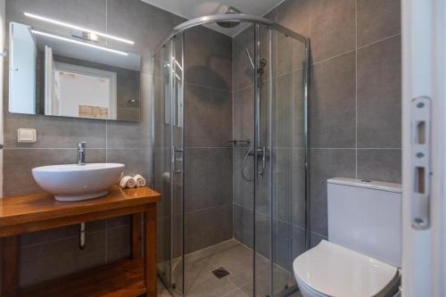 a bathroom with a shower and a sink and a toilet at Majestic Stone Villa Sea View Pool in Andipáta Erísou