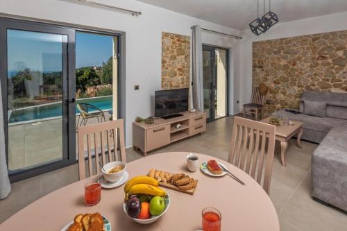 a living room with a table with food on it at Majestic Stone Villa Sea View Pool in Andipáta Erísou