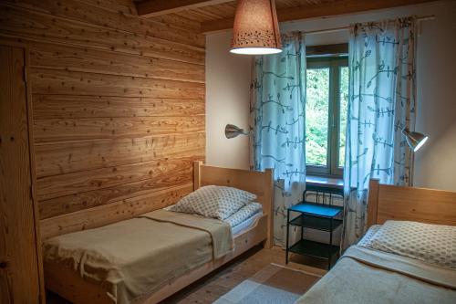 a bedroom with two beds and a window at Chata Kruka - apartamenty in Wetlina