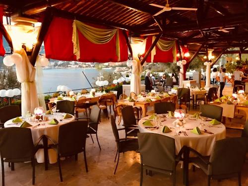 un salón de banquetes con mesas, sillas y gente en Patara Prince Hotel & Resort - Special Category en Kalkan