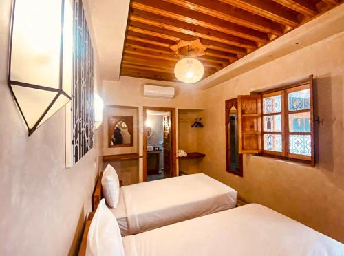 a bedroom with two beds and a ceiling at Riad El Pacha in Rabat