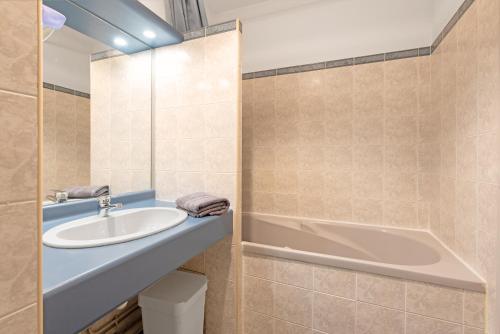 une salle de bain avec un lavabo et une baignoire dans l'établissement T2 Centre Ville avec Parking Gratuit et Jardin, à Toulouse