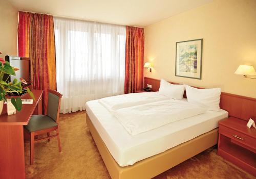 a hotel room with a large bed and a desk at Landhotel Goldener Acker in Morsbach