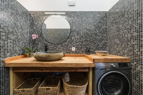 ein Badezimmer mit einer Waschmaschine und einem Spiegel in der Unterkunft La Cabane du Huga N°3 in Lacanau