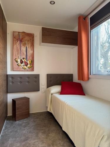 a small bedroom with a bed and a window at Palazzo delle Biscie - Old Tower & Village in Molinella