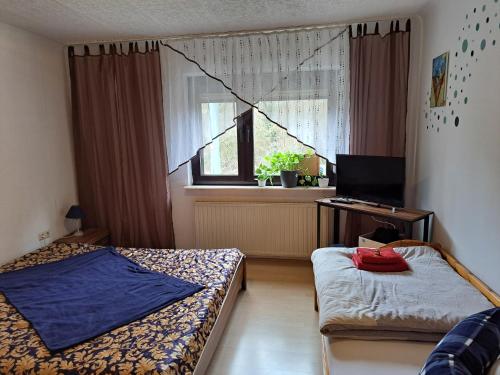 フェルクリンゲンにあるFerienwohnung Niklasのベッドルーム1室(ベッド2台、デスク、窓付)