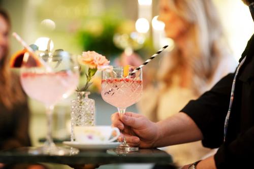 a person holding a wine glass on a table at Strandflickornas Husen invid Havet in Lysekil
