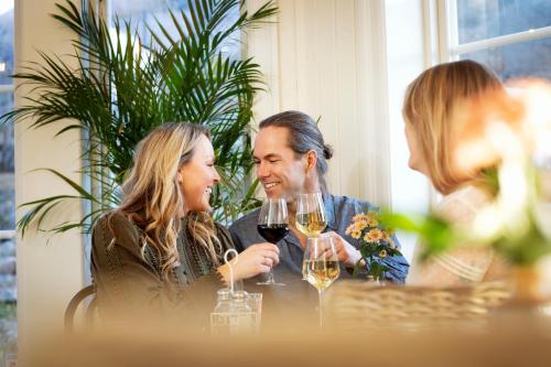 a man and woman sitting at a table with wine glasses at Strandflickornas Husen invid Havet in Lysekil