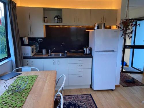 uma cozinha com uma mesa e um frigorífico branco em Ocean Retreat em Brighton