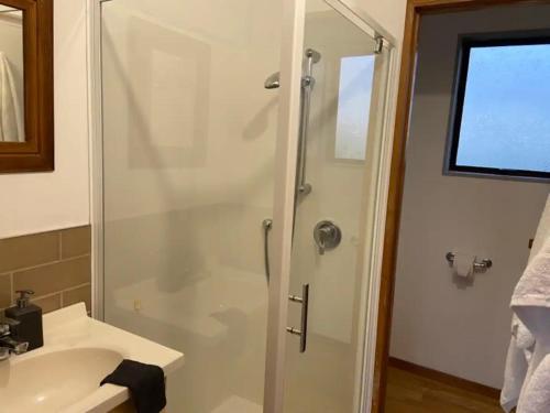uma casa de banho com um chuveiro e um lavatório. em Ocean Retreat em Brighton