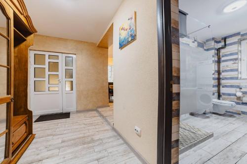 La salle de bains est pourvue de toilettes et d'une porte en verre. dans l'établissement Noua Oasis Bnb-perfect For Groups, à Timișu de Jos