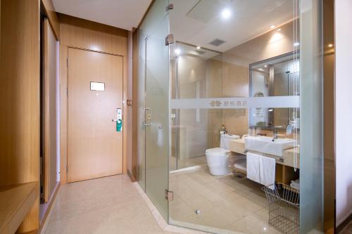a bathroom with a shower and a toilet and a sink at Xiamen Shuyue Hotel in Xiamen