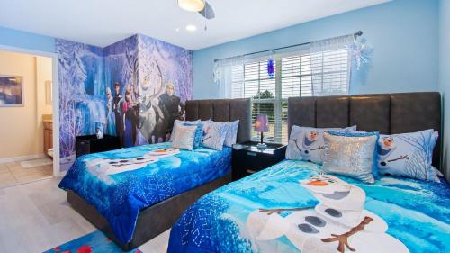 Duas camas num quarto com paredes azuis em Top Villas - Paradise Palms Resort 271 em Kissimmee