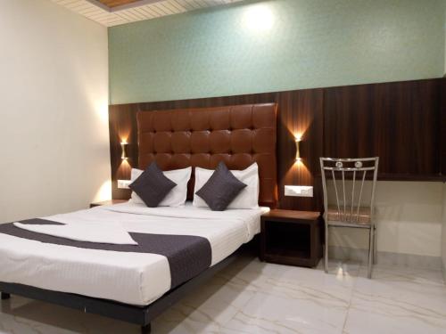 a bedroom with a large bed and a chair at TRI HOTEL in Mumbai