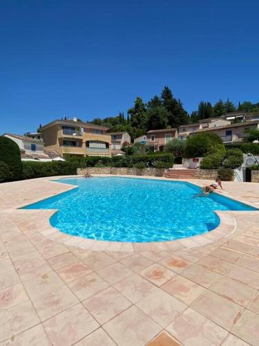 une piscine avec de l'eau bleue dans une cour dans l'établissement Maison individuelle avec jardin ensoleillé, à Auribeau-sur-Siagne