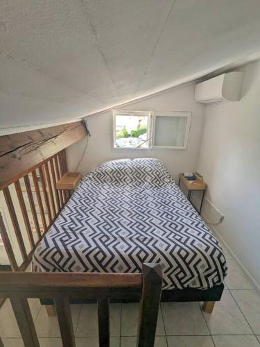 un petit lit dans une chambre avec une fenêtre dans l'établissement Maison individuelle avec jardin ensoleillé, à Auribeau-sur-Siagne