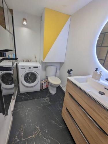 une salle de bain avec une machine à laver et un lavabo dans l'établissement Maison individuelle avec jardin ensoleillé, à Auribeau-sur-Siagne