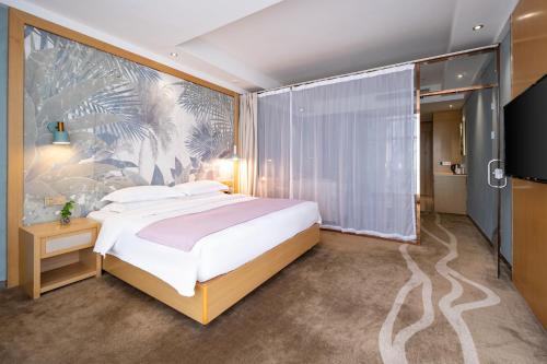 a bedroom with a large bed and a wall mural at Xiamen Shuyue Hotel in Xiamen