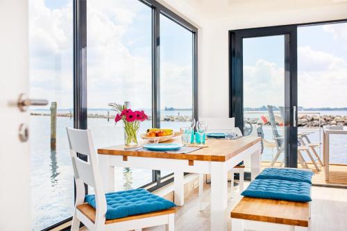 Egernsund的住宿－Hausboot WELL - Husbåd WELL，一间配备有桌子的用餐室,享有水景