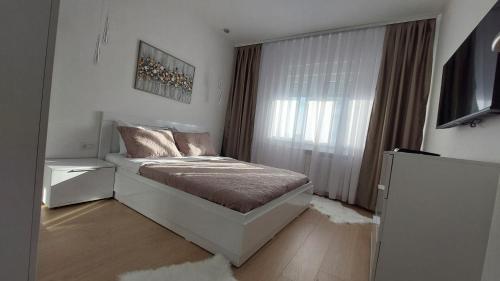 a bedroom with a bed and a television in it at MINA modern & cozy apartment main city square GTC Skopje in Skopje