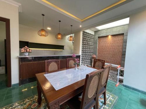 a dining room with a table and chairs in a kitchen at Guesthouse Syariah Griya Truntum in Lawean