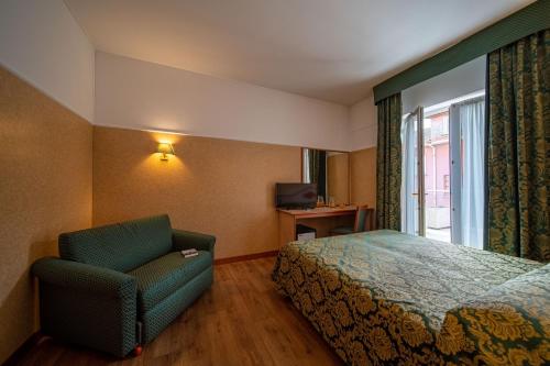a hotel room with a bed and a chair at Hotel Mary in Vicenza