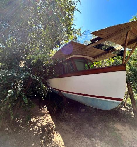 un barco sentado en el suelo junto a un árbol en Casa Barco Campeche, en Florianópolis