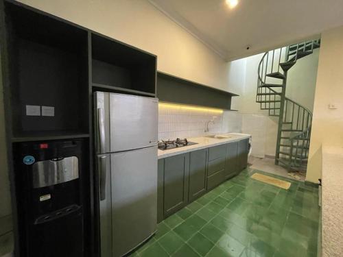 a kitchen with a stainless steel refrigerator and a staircase at Guesthouse Syariah Griya Truntum in Lawean