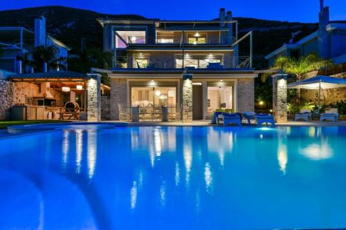 a large swimming pool in front of a house at night at Infinite Blue Epidavros in Ancient Epidavros
