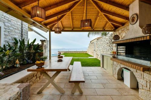 an outdoor patio with a table and a bench at Infinite Blue Epidavros in Ancient Epidavros