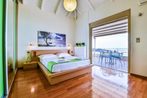 a bedroom with a bed and a balcony at Infinite Blue Epidavros in Ancient Epidavros