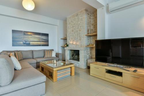 a living room with a large flat screen tv at Infinite Blue Epidavros in Ancient Epidavros