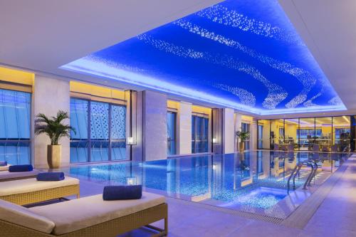 a swimming pool in a building with a blue ceiling at Wanda Realm Jining in Jining