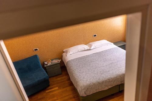 a bedroom with a bed and a blue chair at Hotel Mary in Vicenza