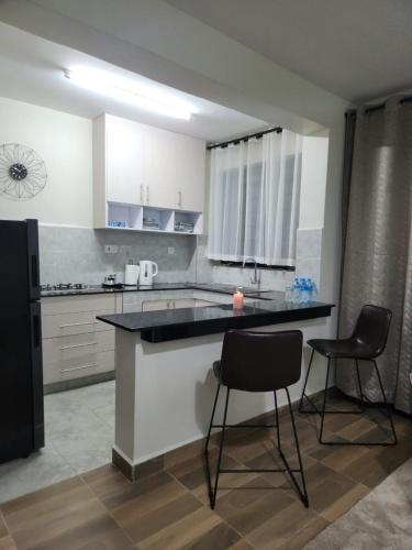 a kitchen with a counter and two chairs in it at 1 bedroom at Alessa Executive Apartments 1103 in Nairobi
