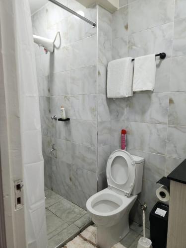 a bathroom with a toilet and a shower with towels at 1 bedroom at Alessa Executive Apartments 1103 in Nairobi